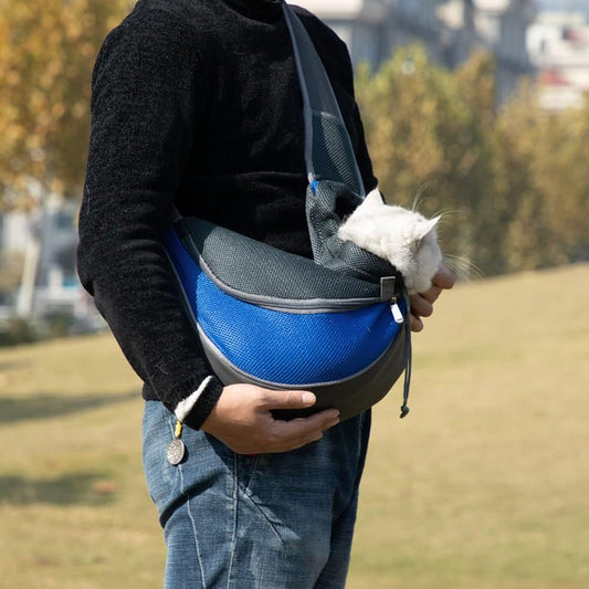 Person carrying a white cat in a blue pet sling carrier bag – hands-free shoulder sling for cats and small pets during outdoor travel