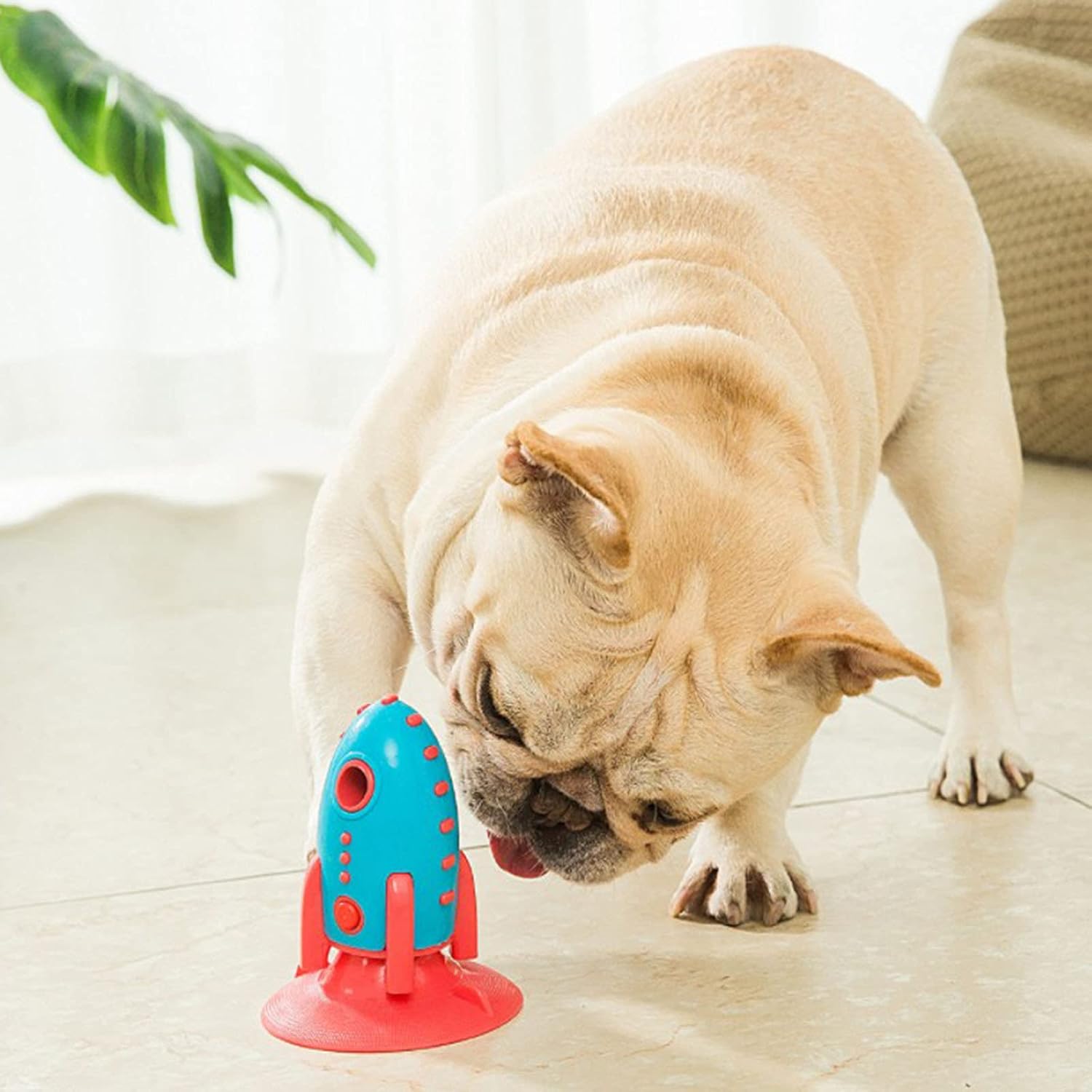 French Bulldog playing with rocket-shaped dog toy – interactive chew toy for dogs, durable treat dispenser for small and medium pets