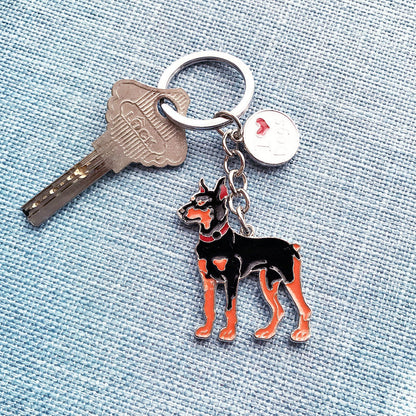 Metal key chain with a black and brown Doberman dog charm attached to a silver key ring
