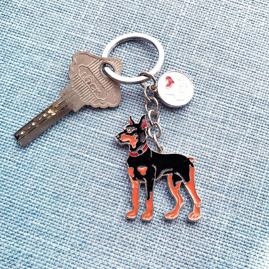Metal key chain with a black and brown Doberman dog charm attached to a silver key ring