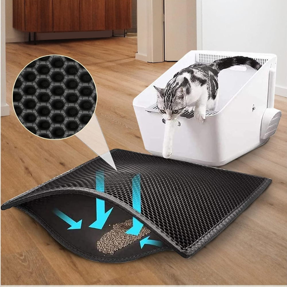 Black double-layer honeycomb cat litter mat placed in front of litter box, showing trapped litter with arrows indicating easy collection and cleaning