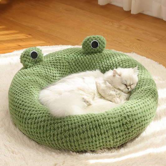 Green frog-shaped pet bed with plush design – fluffy white cat sleeping comfortably on soft cozy cushion for cats and small dogs